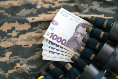 Ukrayna ordu makineli tüfek mermileri ve askeri üniforma üzerinde bir sürü Hryvnia banknotları. Ukrayna ordusunun askerlerine ödemeler, orduya maaşlar. Ukrayna 'da Savaş
