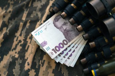 Ukrayna ordu makineli tüfek mermileri ve askeri üniforma üzerinde bir sürü Hryvnia banknotları. Ukrayna ordusunun askerlerine ödemeler, orduya maaşlar. Ukrayna 'da Savaş