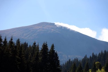 Ukrayna Karpatlarının gökyüzü ve bulutların arka planında asılı duran Hoverla Dağı manzarası