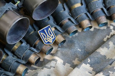 Makineli tüfek kemerindeki Ukrayna sembolü Ukrayna 'nın pikselli askeri kamuflajında yatıyor.