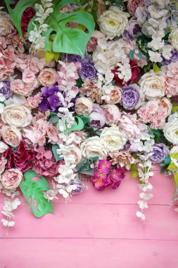 Çiçek arkaplan. El yapımı ahşap arka planda bir sürü yapay çiçek var. Yakın plan.