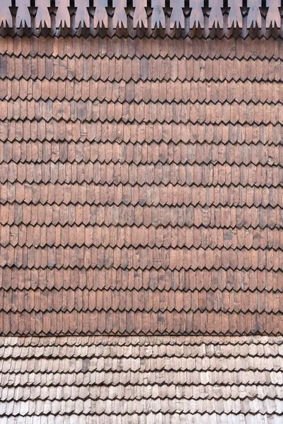 Gray wooden roof tiles background texture. A close up of old gray roof covered with wooden tiles or shingles