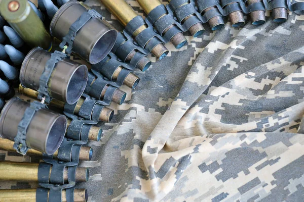 Ukrainian army fabric and machine gun belt shells lies on ukrainian pixeled military camouflage close up