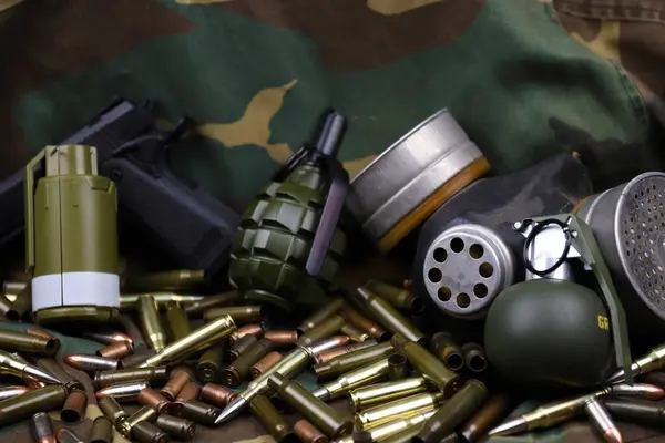 Kamuflaj arka planında farklı cephane ve el bombaları var. Savaşa hazırlanıyorum. Silah bulundurma.