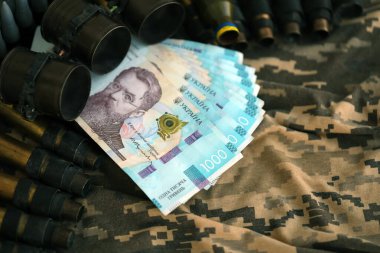 Ukrayna ordu makineli tüfek mermileri ve askeri üniforma üzerinde bir sürü Hryvnia banknotları. Ukrayna ordusunun askerlerine ödemeler, orduya maaşlar. Ukrayna 'da Savaş