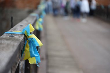 Ulusal Ukrayna bayrağının renginde kurdeleler tırabzana bağlıdır. Sarı-mavi bantlar