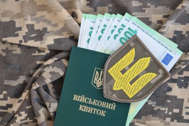 Ukrayna ordusunun ve askeri kimliğin sembolü. Ukraynalı bir askerin kamuflaj üniformasında bolca para var. Askeri personele ödeme kavramı veya askerlik hizmetinden muaf tutulması için rüşvet