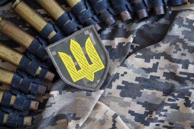Makineli tüfek kemerindeki Ukrayna ordu sembolü Ukrayna piksel askeri kamuflajında yatıyor.