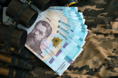 Ukrayna ordu makineli tüfek mermileri ve askeri üniforma üzerinde bir sürü Hryvnia banknotları. Ukrayna ordusunun askerlerine ödemeler, orduya maaşlar. Ukrayna 'da Savaş
