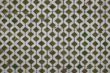 Ekonomik zemin tuğlalarının ve yeşil çimenlerin geometrik arka planı. Eko park dokusu. Çimenler için çukur olan zemin taşından fayanslar. Beton hücrelerin ve çimlerin çevre dostu park yeri