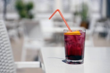 Pembe ve kırmızı renkli egzotik alkollü kokteyl. Restoran masasında limon ve buz var. Renkli pembe buzlu içecek. Kırmızı renkli Mojito.