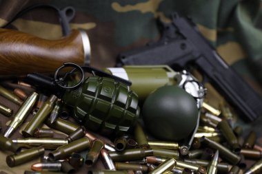 Kamuflaj arka planında farklı cephane ve el bombaları var. Savaşa hazırlanıyorum. Silah bulundurma.
