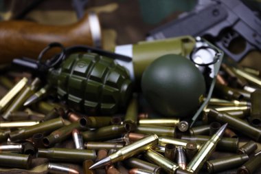 Kamuflaj arka planında farklı cephane ve el bombaları var. Savaşa hazırlanıyorum. Silah bulundurma.