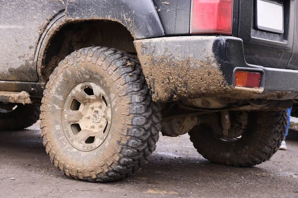 Çamur yolu olan bir kırsal alanda tekerlek yakın çekim. Off-road 4x4 SUV otomobil çamurlu yol alanında sürdükten sonra ditry body ile