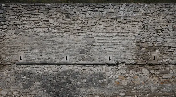 18. yüzyılın kalesinden ya da kalesinden çok eski tuğla bir duvar. Eski, kirli ve çatlak tuğlalarla dolu tam çerçeve duvar.