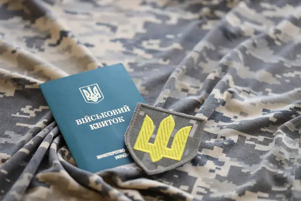 Symbol of Ukrainian army and military ID on the camouflage uniform of a Ukrainian soldier. The concept of war in Ukraine, patriotism and protecting your country from russian occupiers