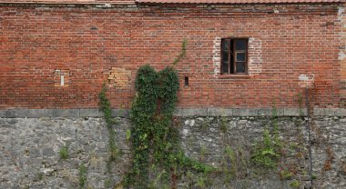 18. yüzyılın kalesinden ya da kalesinden çok eski tuğla bir duvar. Eski, kirli ve çatlak tuğlalarla dolu tam çerçeve duvar.