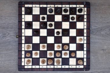 İçi karanlık mahsul odasındaki parçalarla dolu satranç tahtası.