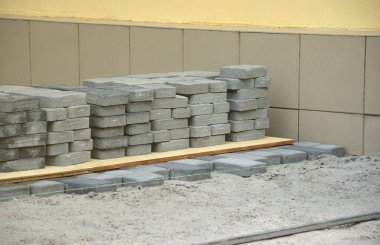 Açık havada uzanan gri ve koyu gri geçit levhaları. Mozaik 'ten Paving Levhaları için malzeme. Çakıl taşı kurulum süreci