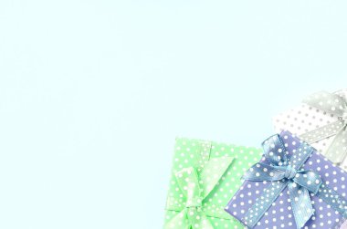 Küçük renkli hediye kutuları şeritler yığını mor bir arka plan üzerinde yatıyor. Üstten görünüm minimalizm düz yatıyordu.