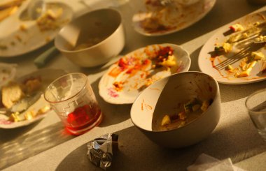 Yemekten sonra masada kaşıklar ve çatallarla kirli tabakları boşalt. Ziyafet sonu konsepti. Yıkanmamış bulaşıklar temizlemeye hazır.