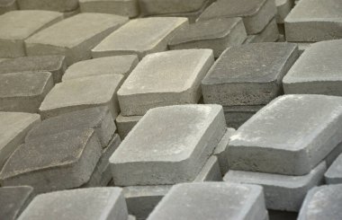 Açık havada uzanan gri ve koyu gri yol levhası yığını. Mozaik yakın plan Paving Levhaları için malzeme. Çakıl taşı üretim deposu