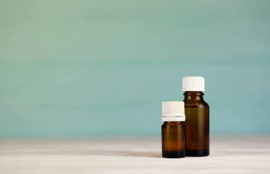 Güzellik bakımı için iki doğal yağ. Çivi, tırnak yağı ve cam şişedeki vücut yağı.