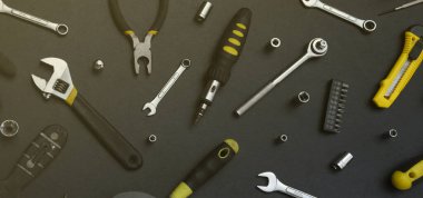 Siyah ahşap masada el işi alet çantası. Onarım ve inşaat işleri için birçok anahtar ve tornavida, sütun ve diğer aletler. Tamirci araçları ayarlandı