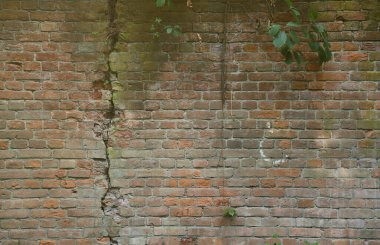 18. yüzyılın kalesinden ya da kalesinden çok eski tuğla bir duvar. Eski, kirli ve çatlak tuğlalarla dolu tam çerçeve duvar.