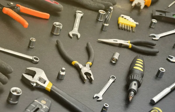 Handyman tool kit on black wooden table. Many wrenches and screwdrivers, pilers and other tools for any types of repair or construction works. Repairman tools set