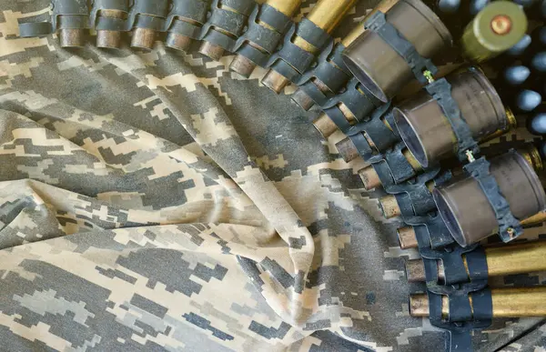 Ukrainian army fabric and machine gun belt shells lies on ukrainian pixeled military camouflage close up