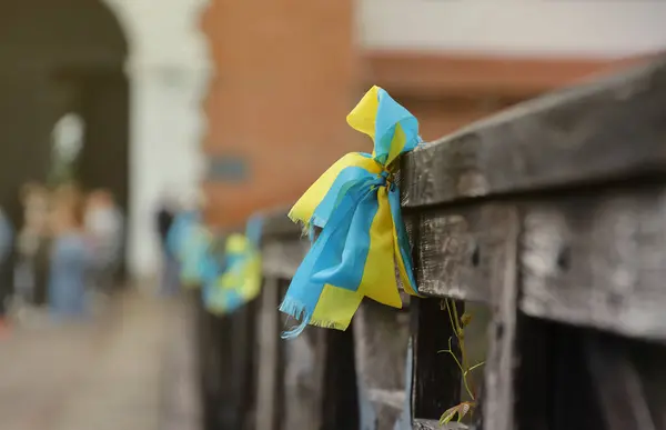 stock image Ribbons in the colors of the national flag of Ukraine are tied to the handrail. Yellow-blue tapes