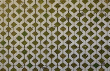 Ekonomik zemin tuğlalarının ve yeşil çimenlerin geometrik arka planı. Eko park dokusu. Çimenler için çukur olan zemin taşından fayanslar. Beton hücrelerin ve çimlerin çevre dostu park yeri