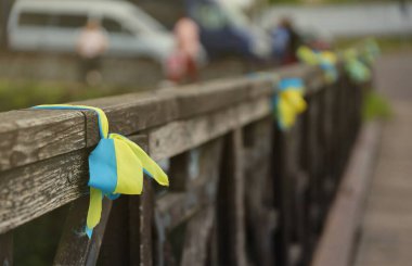 Ulusal Ukrayna bayrağının renginde kurdeleler tırabzana bağlıdır. Sarı-mavi bantlar