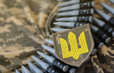 Makineli tüfek kemerindeki Ukrayna ordu sembolü Ukrayna piksel askeri kamuflajında yatıyor.