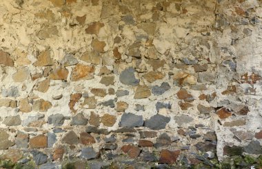 Çimentoyla donatılmış büyük kahverengi ve gri taşlı taş bir duvarın dokusu. Ortaçağ kullanımı için eski kale taşından duvar dokusu. Arka plan olarak taşlı bir binanın parçası