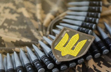 Makineli tüfek kemerindeki Ukrayna ordu sembolü Ukrayna piksel askeri kamuflajında yatıyor.