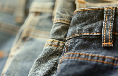 Soyunma odasında bir sürü kot pantolon var. Dolapta pantolon pantolonu var. Satın alma, satma, alışveriş ve modern kıyafetler kavramı