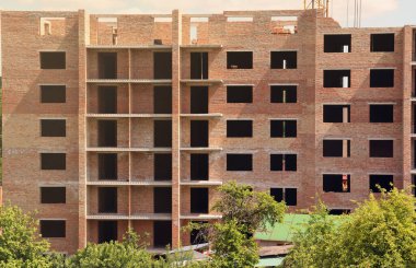 İnşaat halindeki binaları ve çok katlı evleri olan büyük bir şantiye manzarası. Konut yenileme kavramı