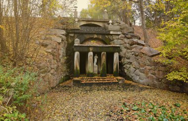 Güzel Doğa Sonbahar manzarası. Bulutlu bir günde altın sarısı yeşilliklerle sonbahar şehir parkının manzarası. Sonbahar yapraklarıyla kaplı Park 'ta yürüyüş yolları.