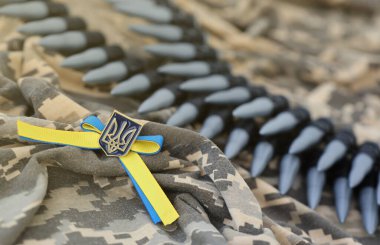 Ukrayna sembolü ve bir Ukraynalı askerin kamuflaj üniformasında makineli tüfek kemeri. Ukrayna 'daki savaş kavramı, vatanseverlik ve ülkenizi Rus işgalcilerden korumak.