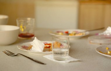 Yemekten sonra masada kaşıklar ve çatallarla kirli tabakları boşalt. Ziyafet sonu konsepti. Yıkanmamış bulaşıklar temizlemeye hazır.