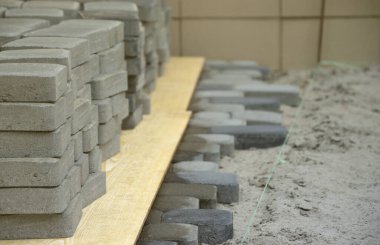 Açık havada uzanan gri ve koyu gri geçit levhaları. Mozaik 'ten Paving Levhaları için malzeme. Çakıl taşı kurulum süreci