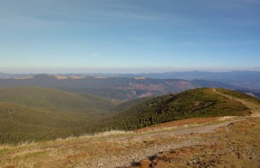 Ukrayna Karpatlarının gökyüzü ve bulutların arka planında asılı duran Hoverla Dağı manzarası