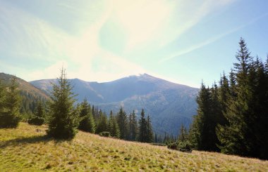 Ukrayna Karpatlarının gökyüzü ve bulutların arka planında asılı duran Hoverla Dağı manzarası