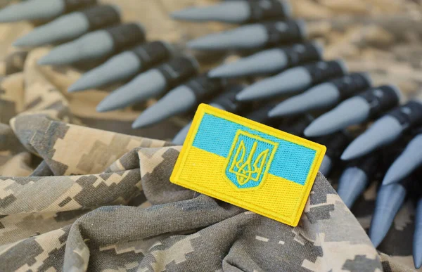 Ukrainian symbol and a machine gun belt on the camouflage uniform of a Ukrainian soldier. The Concept of war in Ukraine, patriotism and protecting your country from russian occupiers