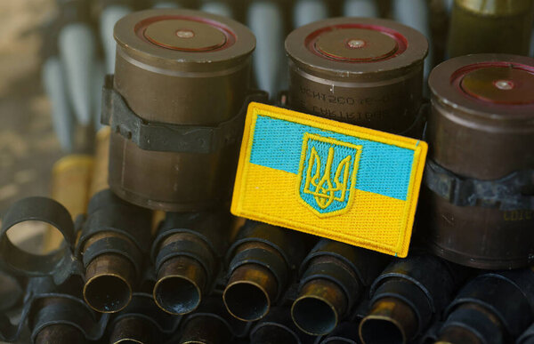 Украинский символ на пулемётном поясе лежит на украинском пиксельном военном камуфляже вблизи