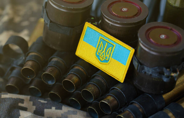 Украинский символ на пулемётном поясе лежит на украинском пиксельном военном камуфляже вблизи