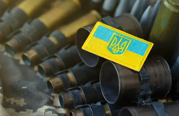 Ukrainian symbol on machine gun belt lies on ukrainian pixeled military camouflage.