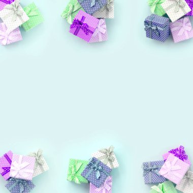 Küçük renkli hediye kutuları şeritler yığınları mor bir arka plan üzerinde yatıyor. Üstten görünüm desen minimalizm düz yatıyordu.